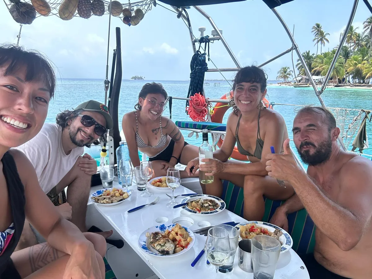 Travelers sharing lunch on the deck of the shared sailboat