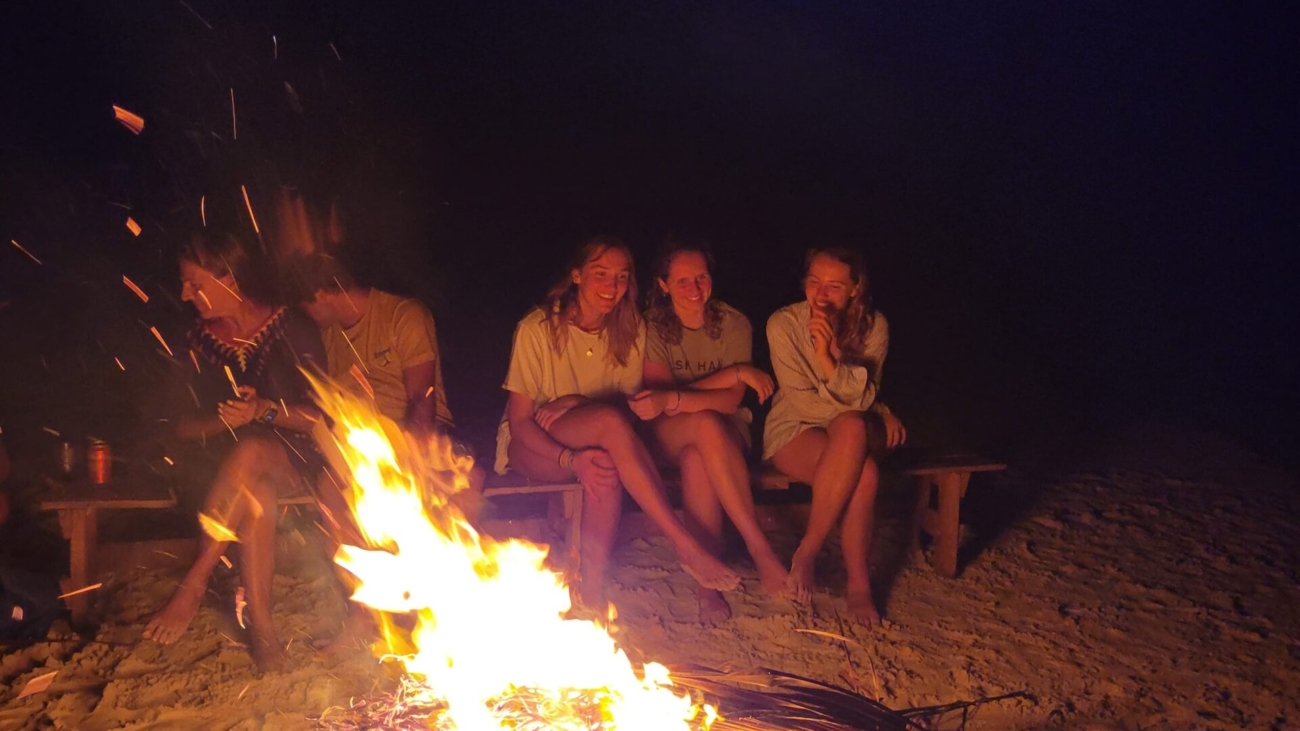 Backpackers enjoying a bonfire on the beach during a San Blas sailing trip