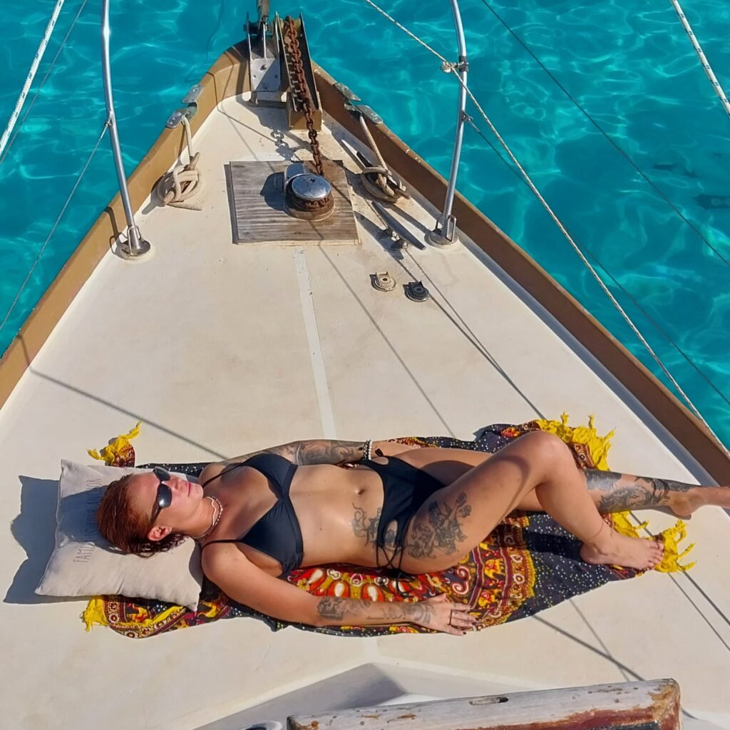 a women sunbathing on sailboat deck